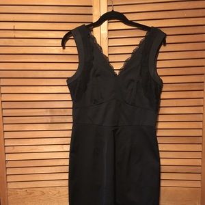 Black cocktail dress with black lace detailing.